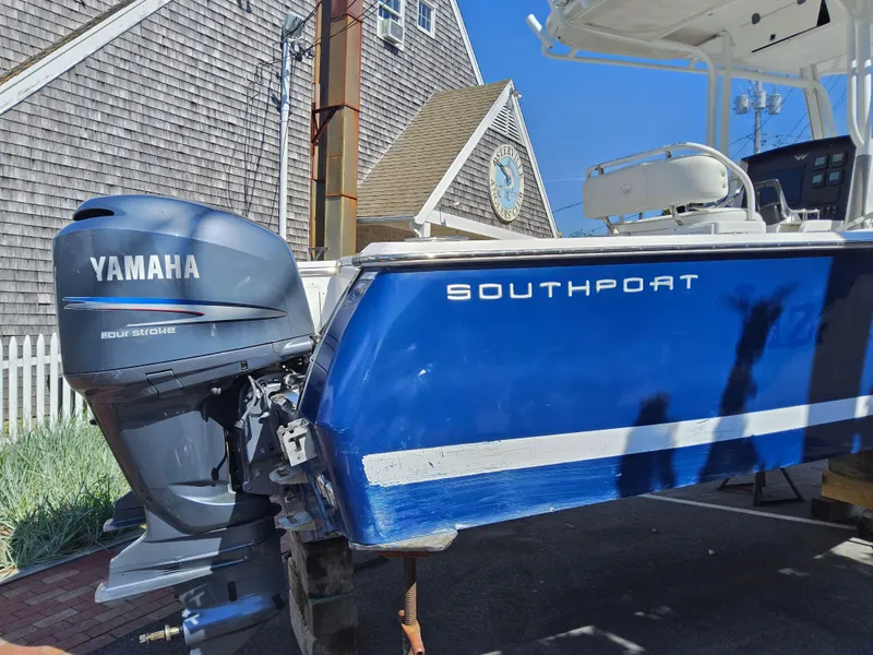 Slide: The Image of 2007 Southport 26 Center Console boat with Yamaha engine, parked near a house. - 6