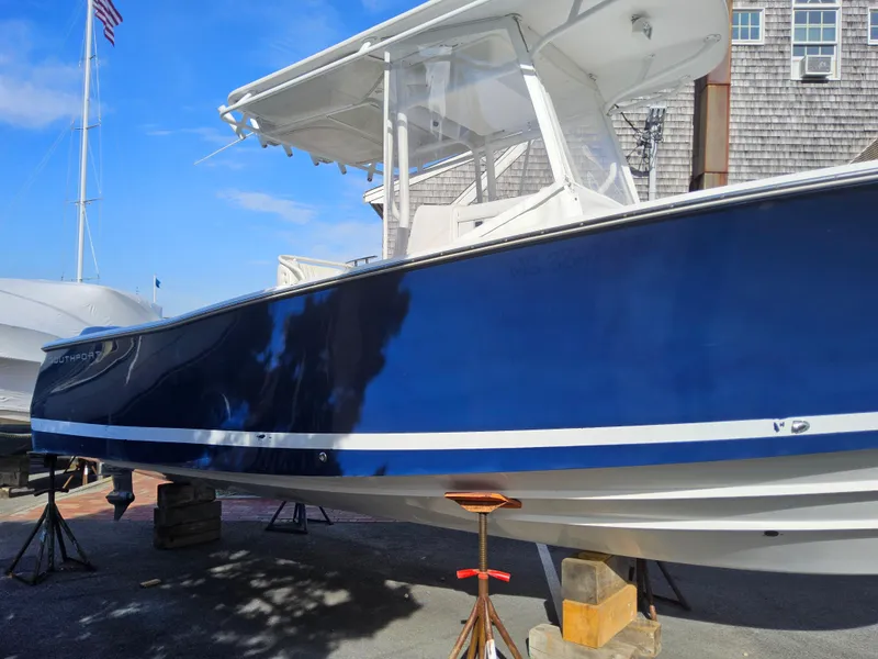 Slide: The Image of 2007 Southport 26 Center Console boat with blue hull on stands, outdoor setting. - 7