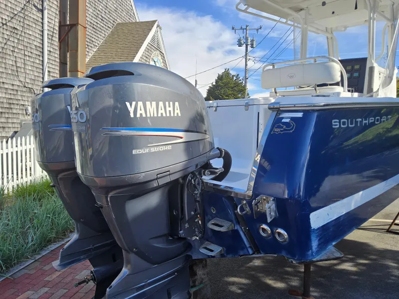 Slide: The Image of 2007 Southport 26 Center Console with Yamaha outboard engines, docked near a coastal building. - 9