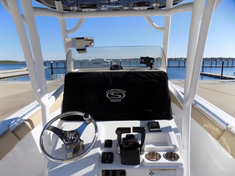 Slide: The Image of 2017 Sportsman Heritage 251 Center Console boat at dock, featuring steering wheel and controls. - 11