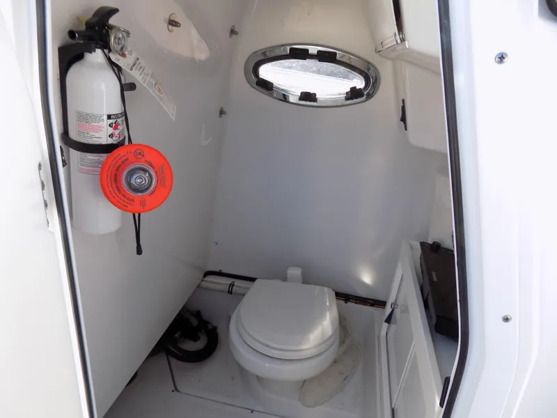 Slide: The Image of 2017 Sportsman Heritage 251 Center Console boat interior with toilet and fire extinguisher. - 25