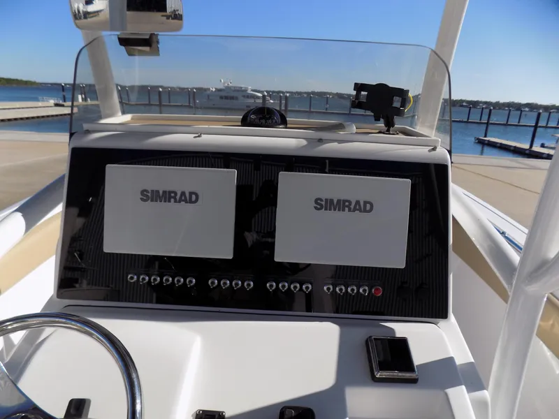 Slide: The Image of 2017 Sportsman Heritage 251 Center Console dashboard with dual Simrad displays at marina. - 6