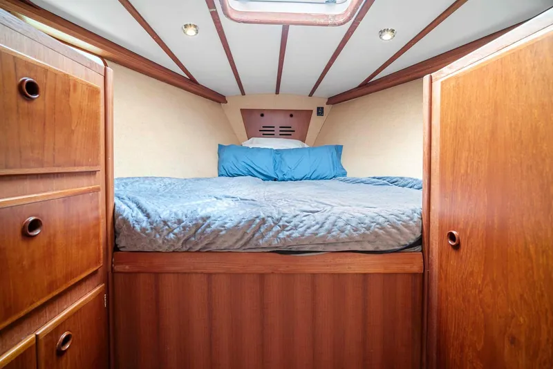 Slide: The Image of Cozy cabin interior of 1981 Pearson 530 sailboat with wooden furnishings and bed. - 23