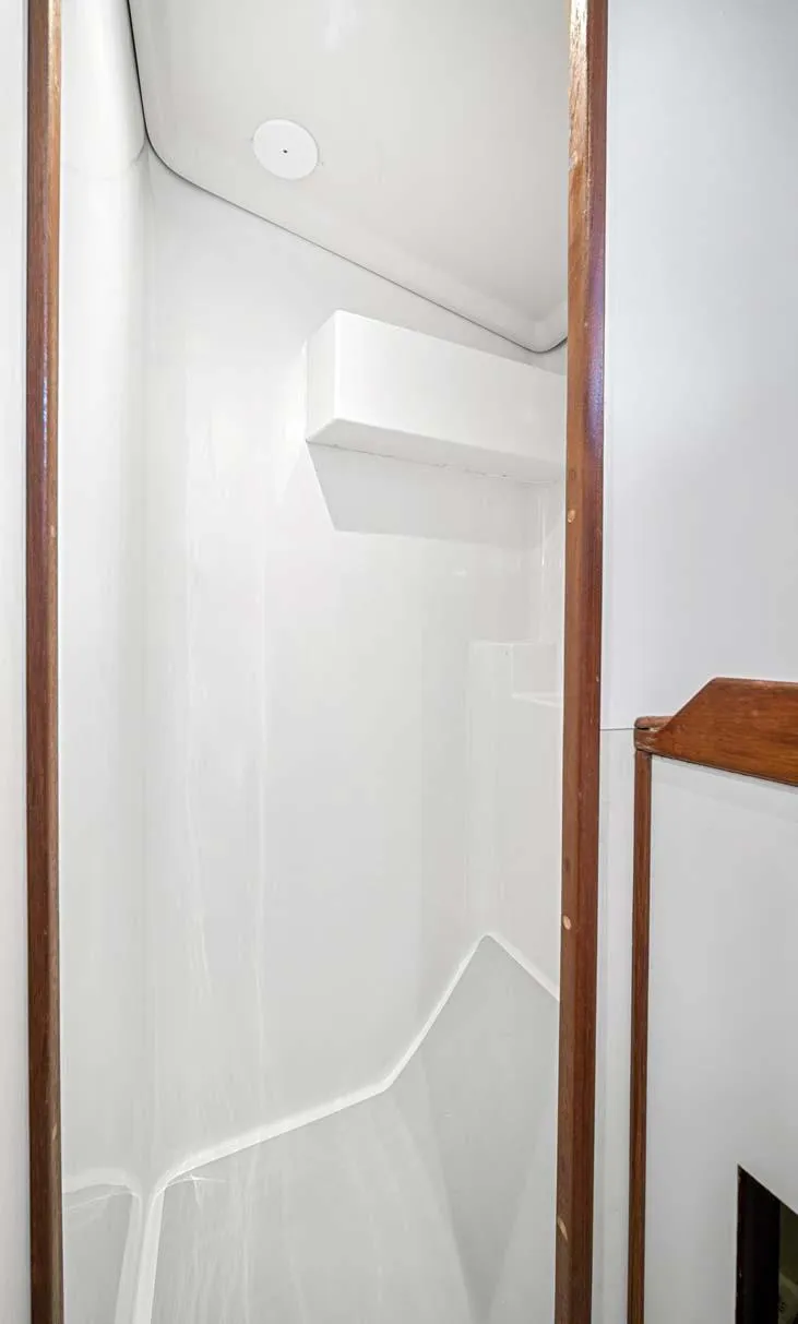 Slide: The Image of 1981 Pearson 530 yacht interior shower with white walls and wooden trim. - 25