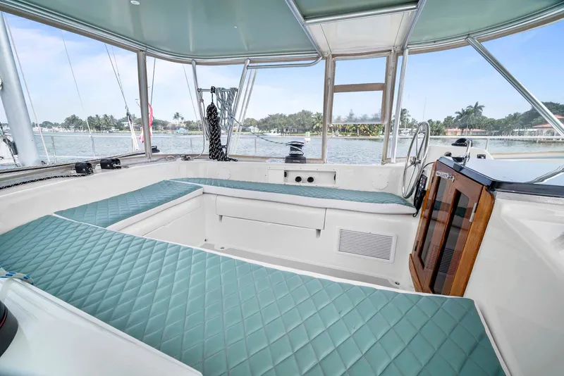 Slide: The Image of Interior of 1981 Pearson 530 sailboat with teal cushioned seating and panoramic windows. - 44