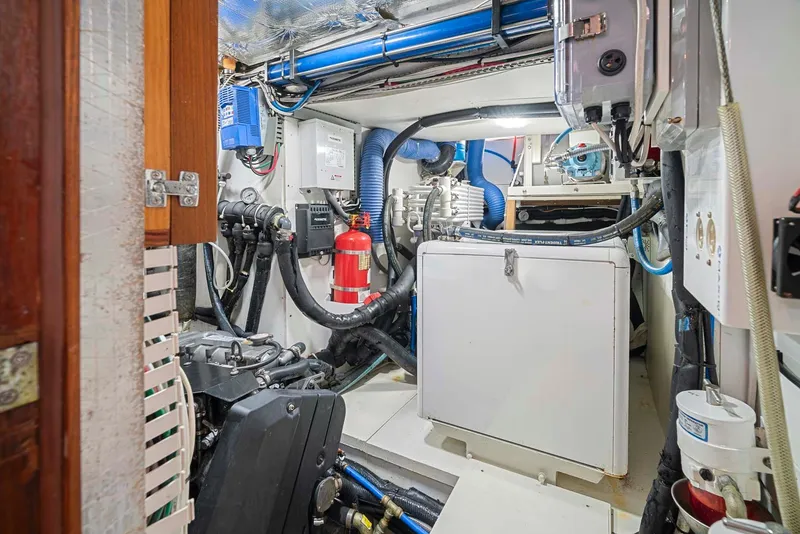 Slide: The Image of Engine room of 1981 Pearson 530 yacht with mechanical equipment and fire extinguisher. - 48