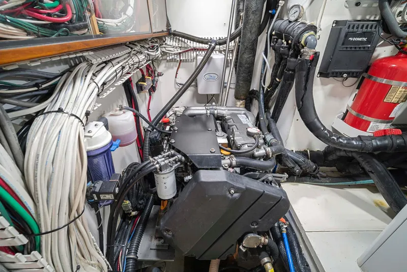 Slide: The Image of Engine room of 1981 Pearson 530 sailboat with wiring and fire extinguisher. - 49