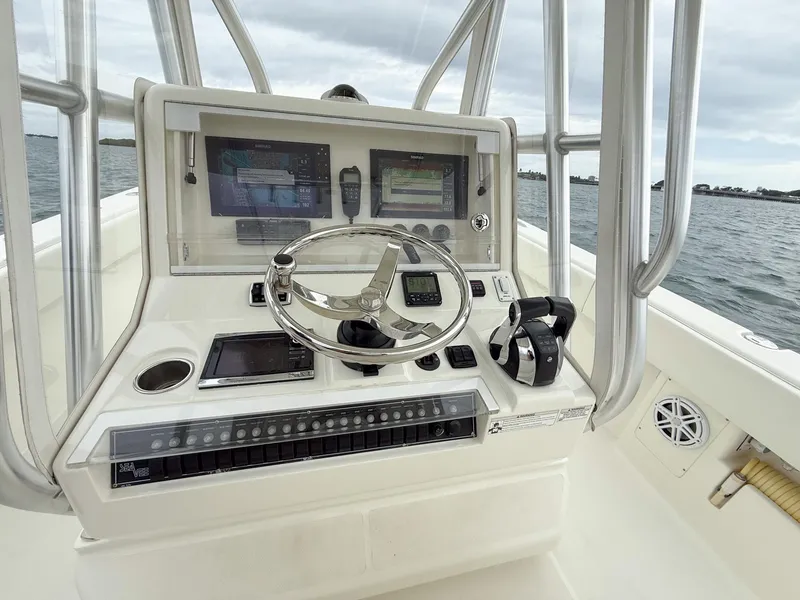 Slide: The Image of 2015 SeaVee 340Z boat console with steering wheel and navigation screens on open water. - 13