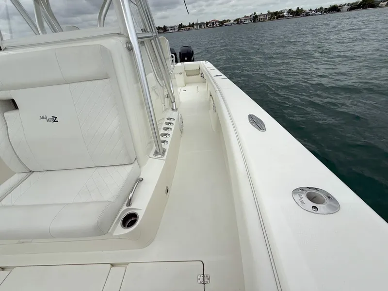 Slide: The Image of 2015 SeaVee 340Z boat deck with white seating, on calm water. - 19
