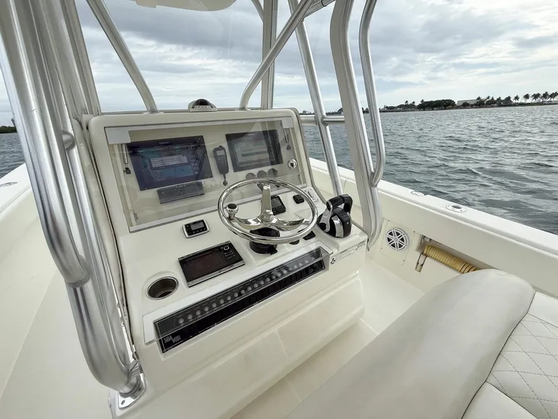Slide: The Image of 2015 SeaVee 340Z boat console with steering wheel and navigation screens on open water. - 21