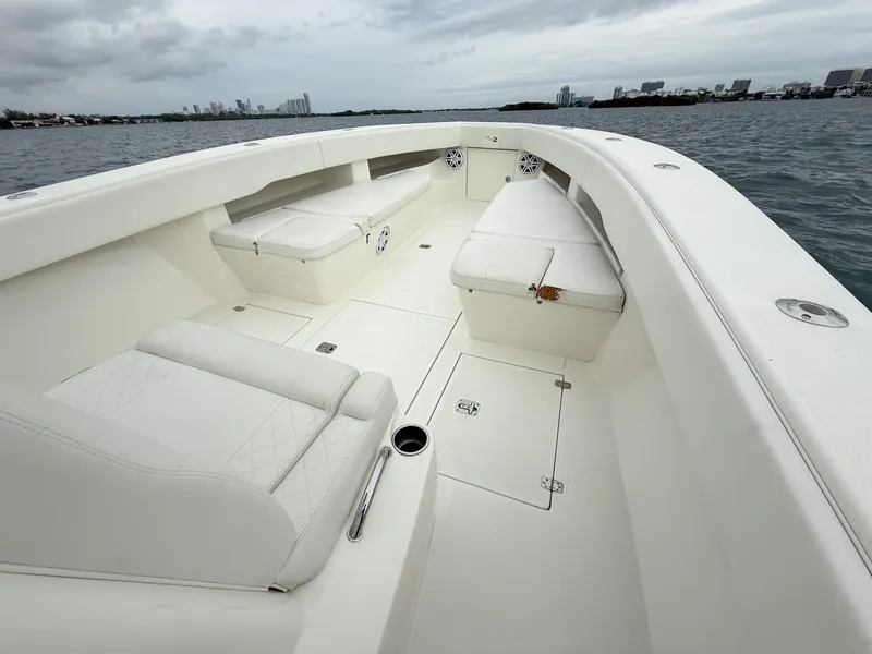Slide: The Image of 2015 SeaVee 340Z boat interior with white seating and open deck on the water. - 31