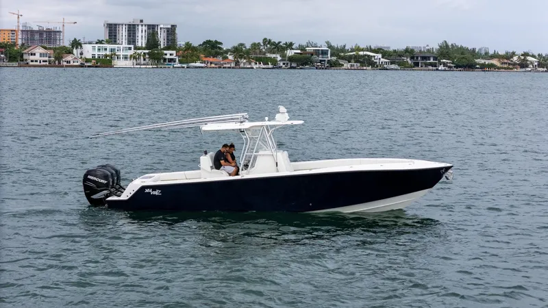 Slide: The Image of 2015 SeaVee 340Z boat cruising on a calm waterway near a coastal city. - 4