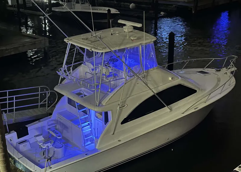 Slide: The Image of 2000 Ocean Yachts Super Sport with blue deck lights at night. - 17