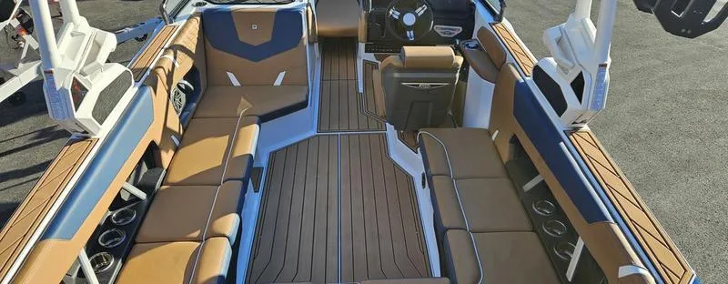 Slide: The Image of 2025 Nautique Super Air Nautique GS22 interior with tan and blue seating, sleek design. - 14