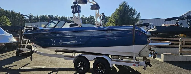 Slide: The Image of 2025 Nautique Super Air Nautique GS22 boat on trailer, blue and white design. - 4