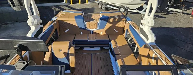 Slide: The Image of 2025 Nautique Super Air Nautique GS22 interior with tan and blue seating. - 6