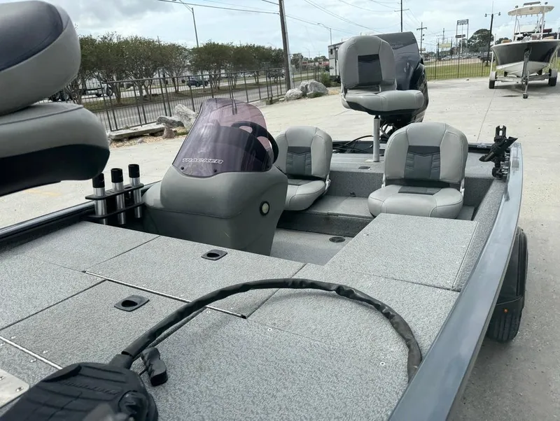 Slide: The Image of 2018 Tracker Pro 170 boat interior with seating and console, parked outdoors. - 18