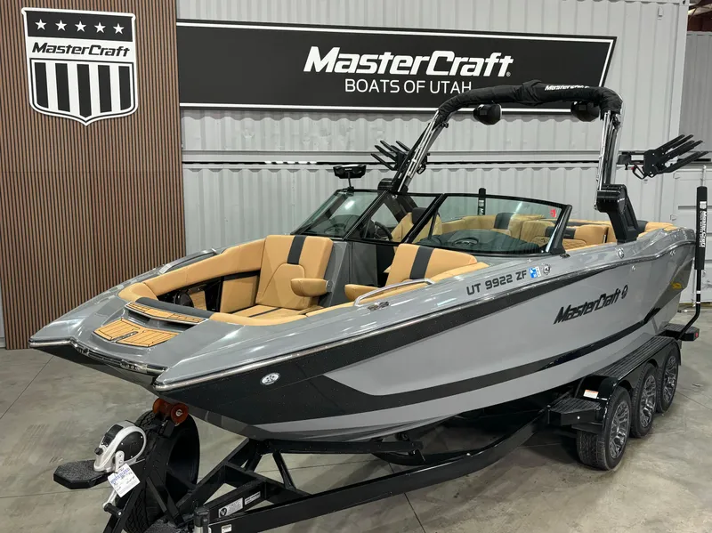 Slide: The Image of 2023 MasterCraft X24 boat in showroom, gray with tan interior, on trailer. - 15