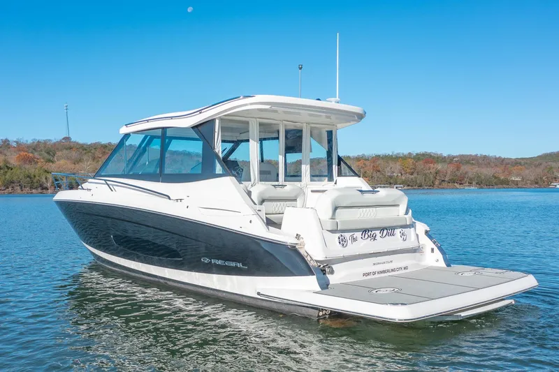 Slide: The Image of 2021 Regal 36 Grande Coupe boat on a serene lake. - 0