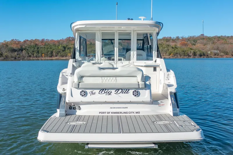 Slide: The Image of 2021 Regal 36 Grande Coupe boat on water, rear view with "The Big Dill" name. - 1