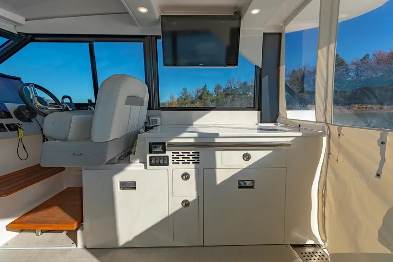 Slide: The Image of 2021 Regal 36 Grande Coupe interior with helm, seating, and panoramic windows. - 14