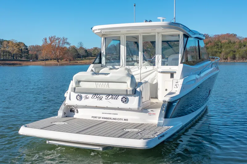 Slide: The Image of 2021 Regal 36 Grande Coupe boat on a serene lake. - 2