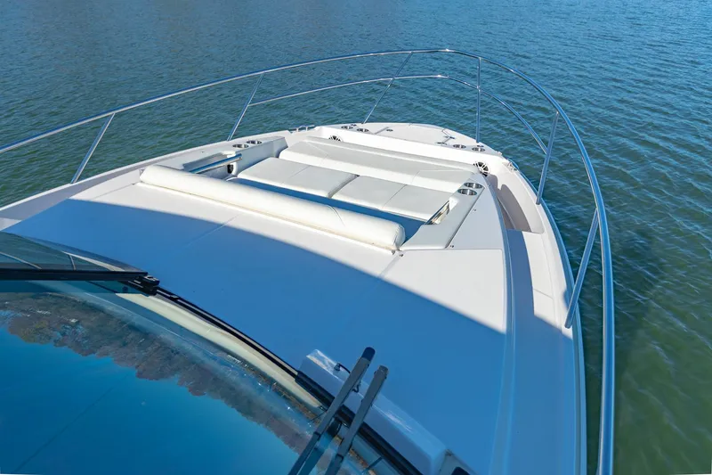 Slide: The Image of 2021 Regal 36 Grande Coupe yacht on calm water, showcasing sleek deck design. - 24