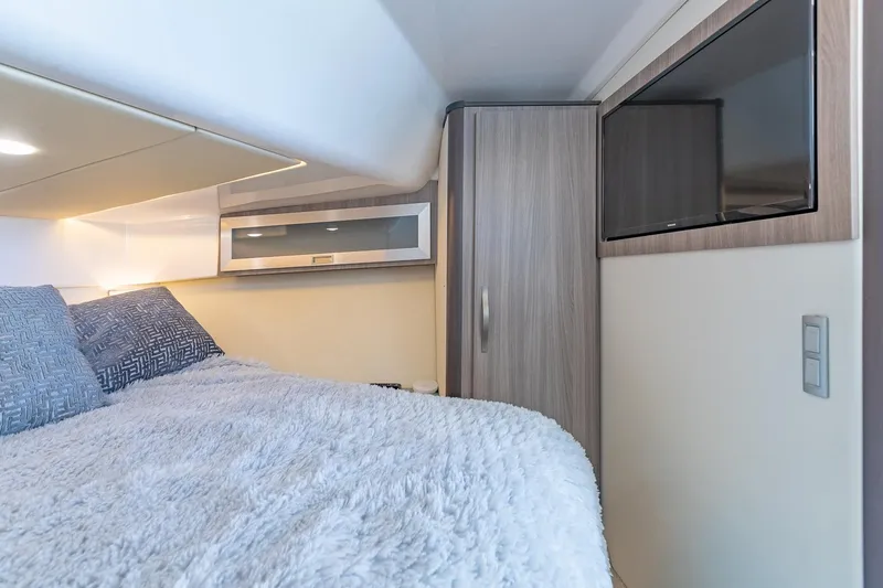 Slide: The Image of Interior cabin of 2021 Regal 36 Grande Coupe with cozy bedding and modern design. - 29