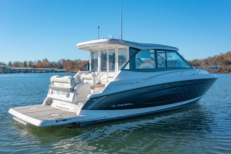 Slide: The Image of 2021 Regal 36 Grande Coupe boat on a serene lake. - 3