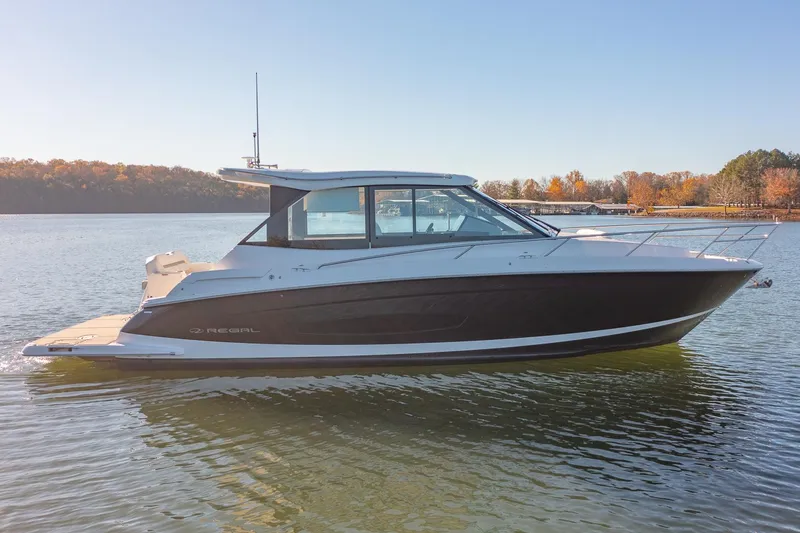 Slide: The Image of 2021 Regal 36 Grande Coupe boat on calm lake with autumn trees. - 4