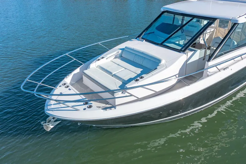Slide: The Image of 2021 Regal 36 Grande Coupe boat on calm water, featuring sleek design and spacious deck. - 7