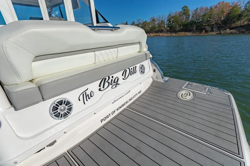 Slide: The Image of 2021 Regal 36 Grande Coupe boat with "The Big Dill" name, docked on a serene lake. - 9