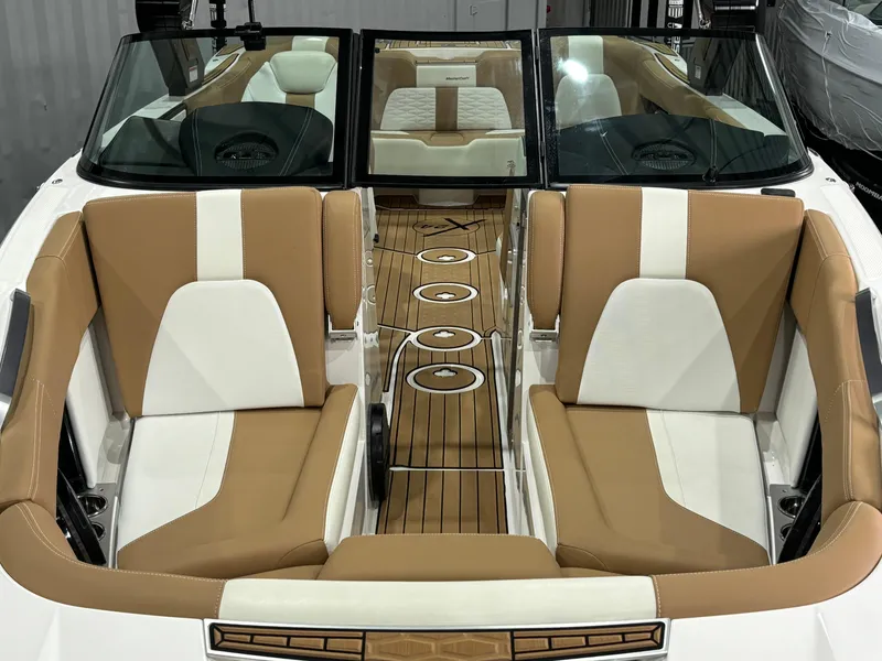 Slide: The Image of 2024 MasterCraft X24 boat interior with tan and white seating, wooden flooring. - 10