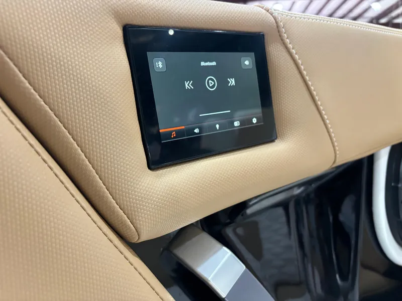 Slide: The Image of 2024 MasterCraft X24 interior touchscreen displaying Bluetooth controls on tan upholstery. - 14