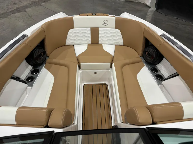 Slide: The Image of 2024 MasterCraft X24 boat interior with tan and white seating, featuring premium speakers. - 17