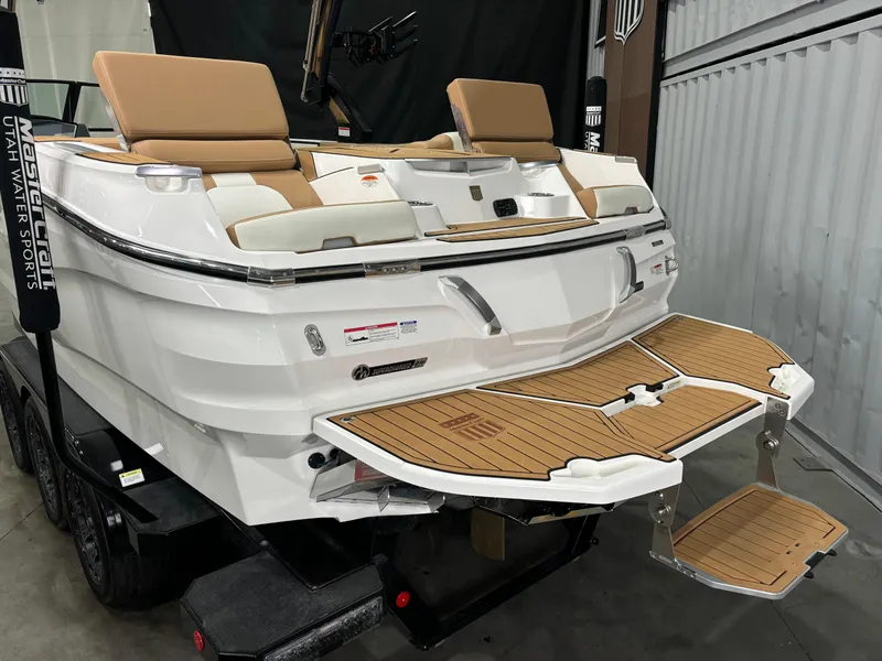 Slide: The Image of 2024 MasterCraft X24 boat with teak swim platform and tan seating in a showroom. - 4