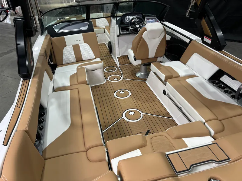 Slide: The Image of 2024 MasterCraft X24 boat interior with tan and white seating, sleek design, and modern dashboard. - 7