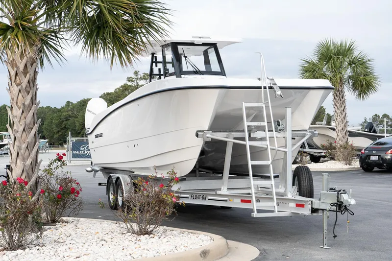 Slide: The Image of 2025 Twin Vee 280 GFX2 CC boat on trailer, parked near palm trees. - 3