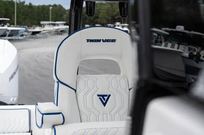 Slide: The Image of 2025 Twin Vee 280 GFX2 CC boat seat with logo, marina background. - 34