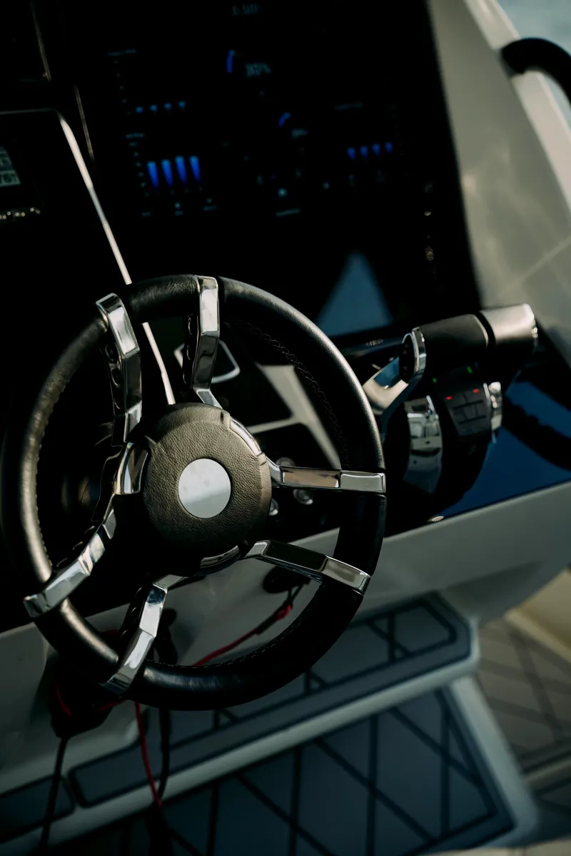 Slide: The Image of Steering wheel of 2021 Deep Impact 399 Sport boat, showcasing modern design and controls. - 11