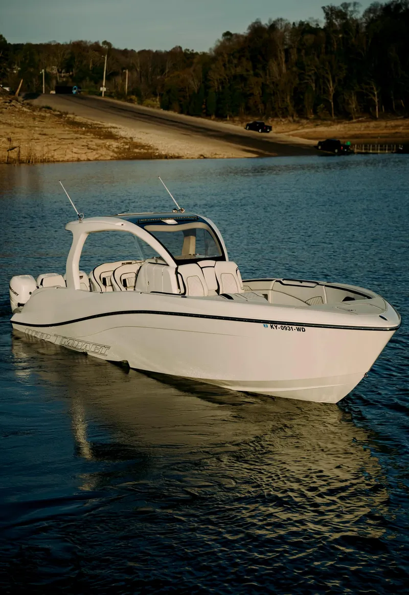 Slide: The Image of 2021 Deep Impact 399 Sport boat on calm water near shoreline. - 2