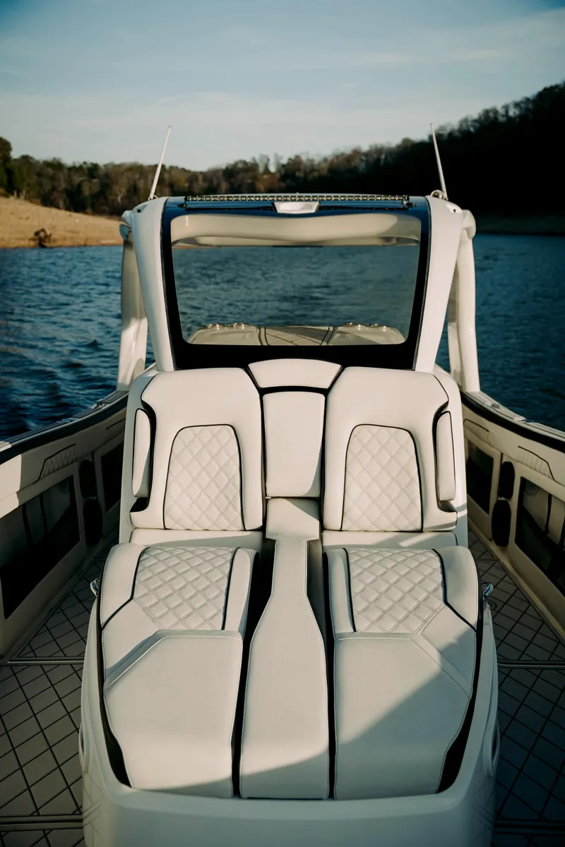 Slide: The Image of 2021 Deep Impact 399 Sport boat interior with luxurious seating on a serene lake. - 7