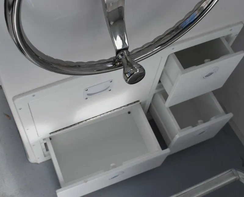 Slide: The Image of Steiger Craft 23 Miami 2025 boat interior with open storage drawers and steering wheel. - 20