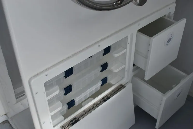 Slide: The Image of Steiger Craft 23 Miami 2025 boat storage compartments with open drawers and shelves. - 21
