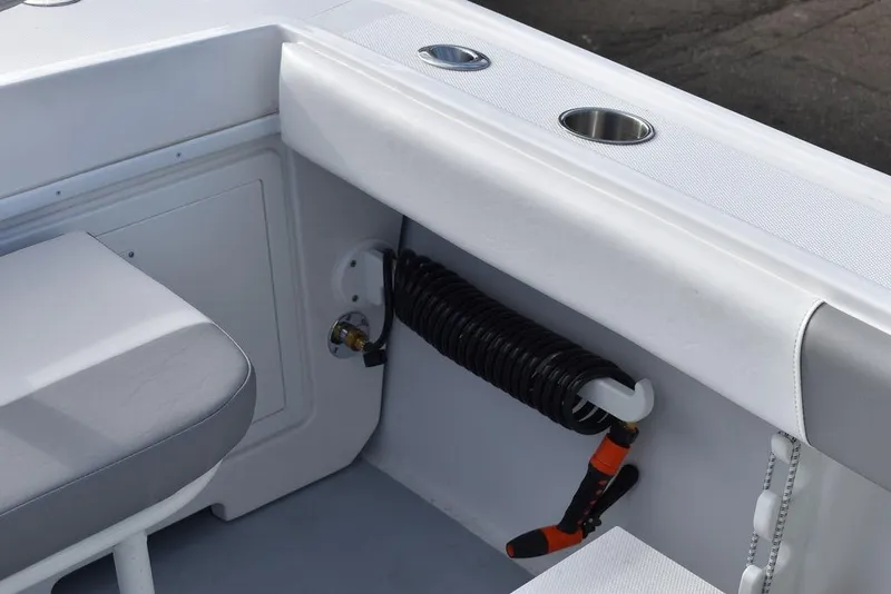 Slide: The Image of 2025 Steiger Craft 23 Miami boat interior with coiled hose and cup holders. - 25