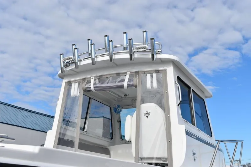 Slide: The Image of 2025 Steiger Craft 23 Miami boat with rod holders against a cloudy sky. - 6