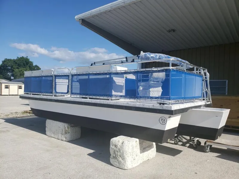 Slide: The Image of 2025 A&M Manufacturing Salty 23 boat on blocks, blue and white design, outdoor setting. - 14