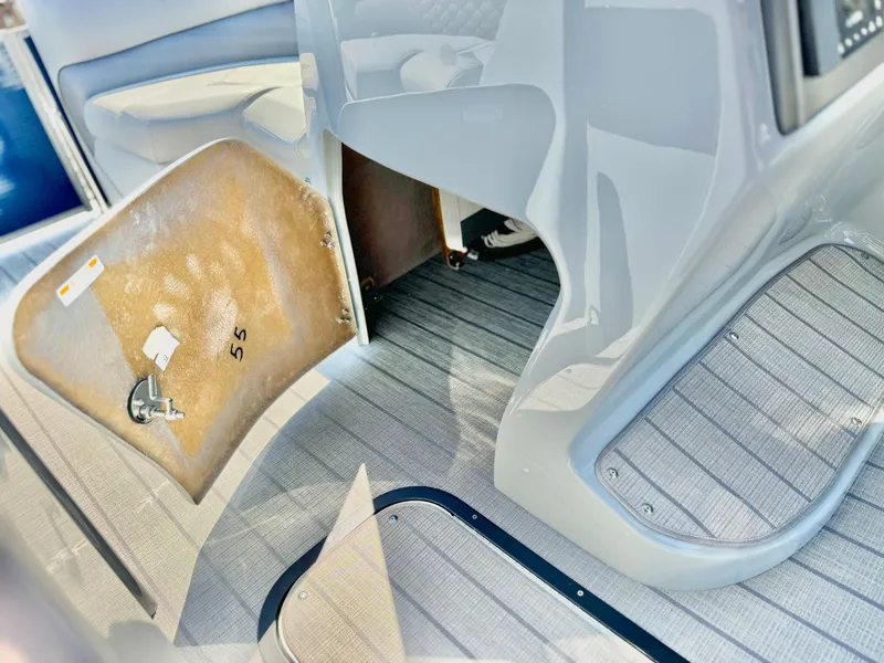 Slide: The Image of Interior view of 2025 Manitou 23 LX RFXW boat with open storage compartment. - 15