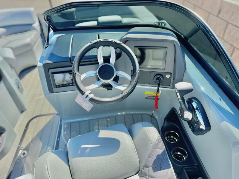 Slide: The Image of 2025 Manitou 23 LX RFXW boat dashboard with steering wheel and controls. - 16