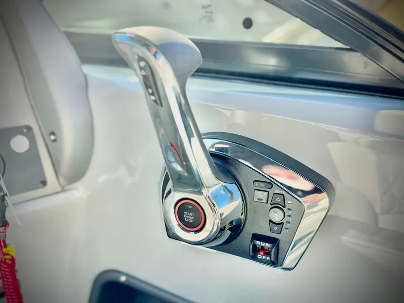 Slide: The Image of Close-up of 2025 Manitou 23 LX RFXW boat throttle control. - 17
